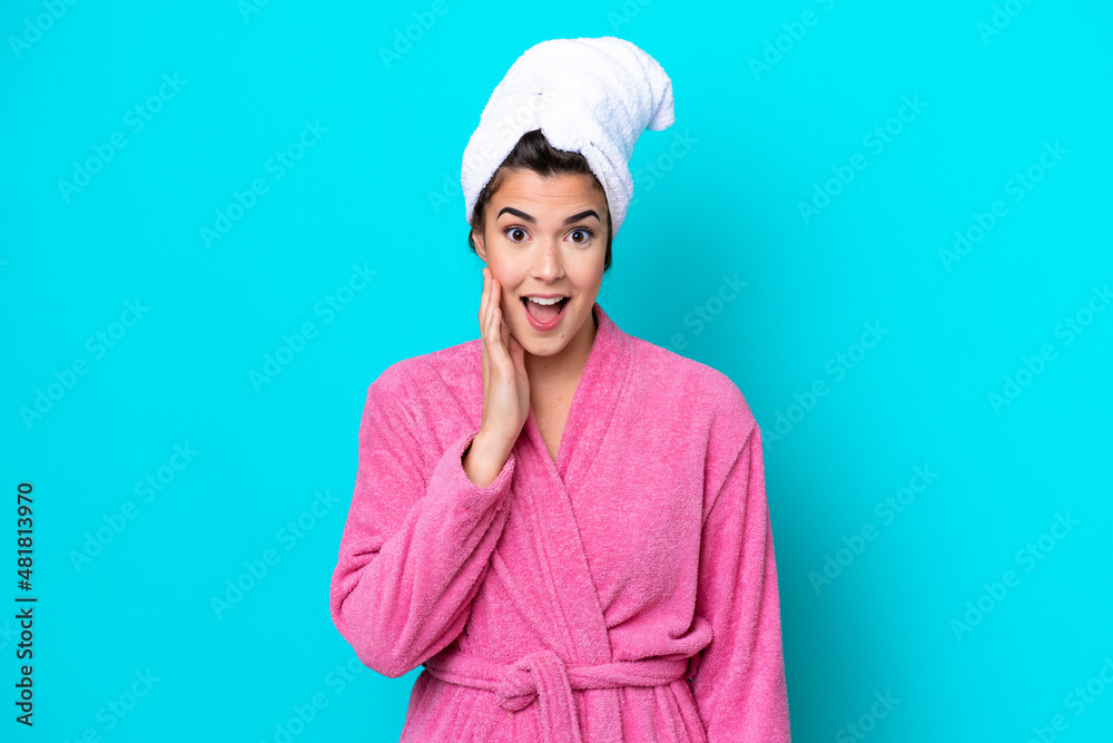 Young Brazilian woman with a bathrobe isolated on blue background with surprise and shocked facial expression Young Brazilian woman with a bathrobe isolated on blue background with surprise and shocked facial expression