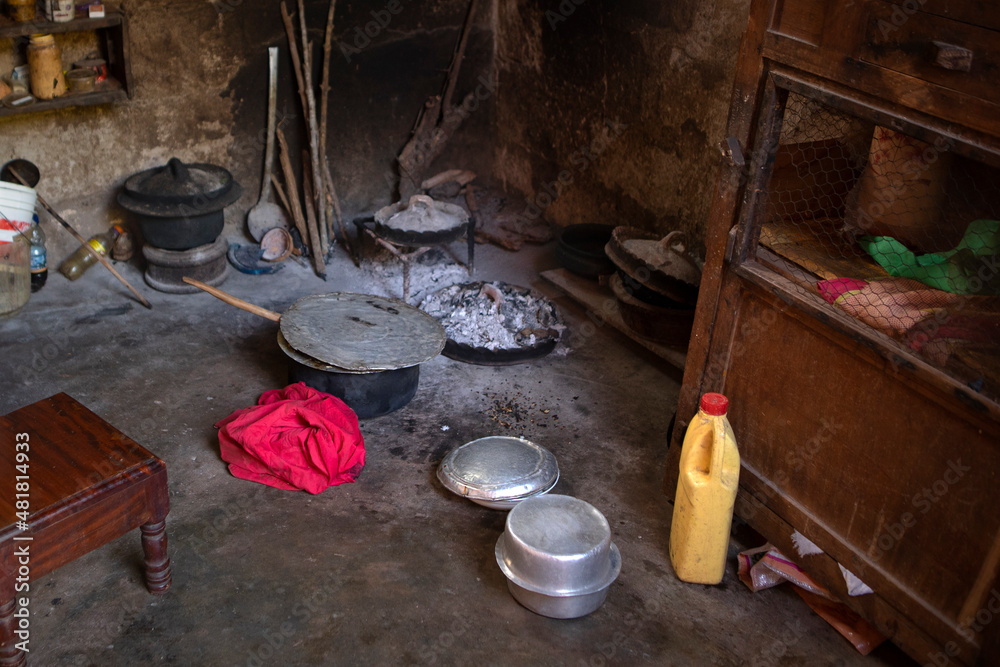 The kitchen inside a hut. African kitchen interior with hearth and stove. Interior of the modest vintage style poor kitchen, pots and utensils lay on the ground. Hut kitchen in african village.