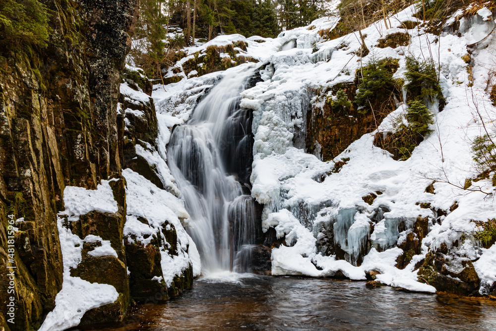 Long high waterfall in mountains full of snow and ice around Long high waterfall in mountains full of snow and ice around