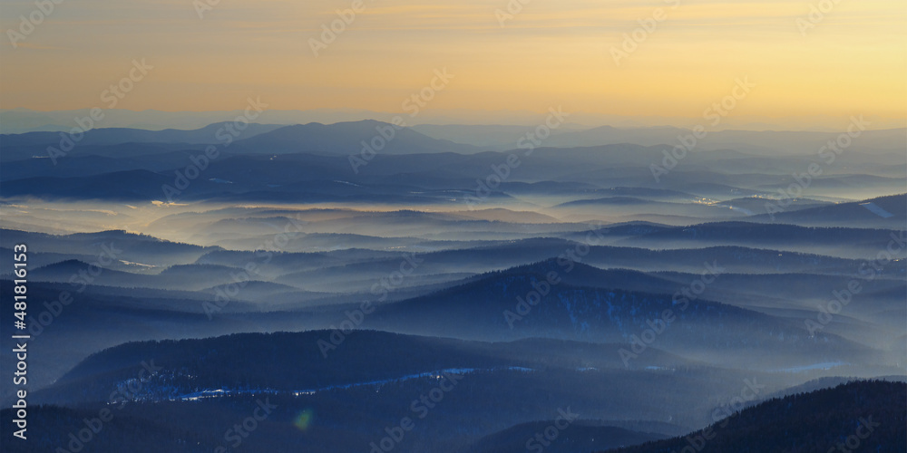 Colorful mountain hills with tonal perspective at winter evening at sunset. Abstract panoramic landscape in Gornaya Shoria, Sheregesh ski resort in Russia Foggy Mountains nature environment