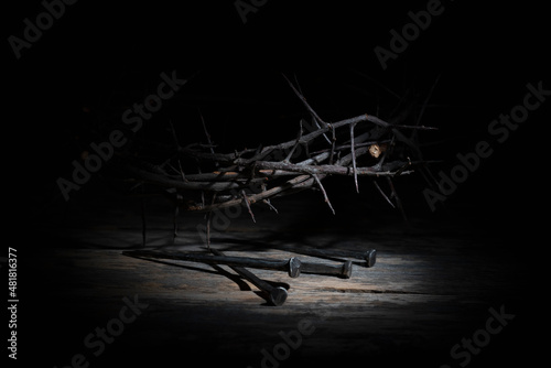 Conceptual image of rosary, ancient Bible and thorn wreath against black background as symbol of death, resurrection of Jesus Christ.