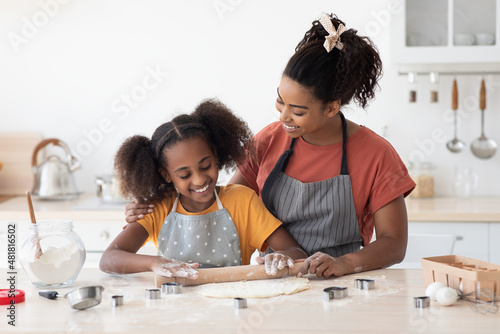 Loving mother helping her teen daughter with baking