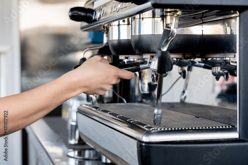 hand of a barmaid taking a coffee on the machine.