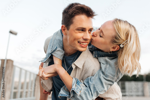 summer holidays, love and people concept - happy young couple kissing and hugging on roof top