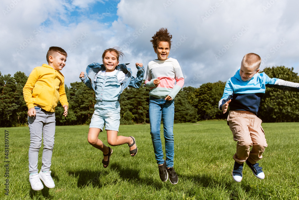 Obraz premium childhood, leisure and people concept - group of happy kids jumping and having fun at park