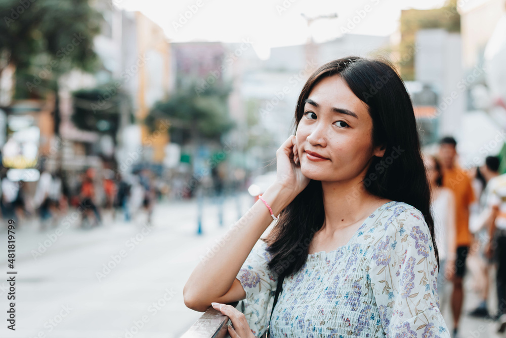 Fototapeta premium Close up of beautiful Asian woman with city blurred background.