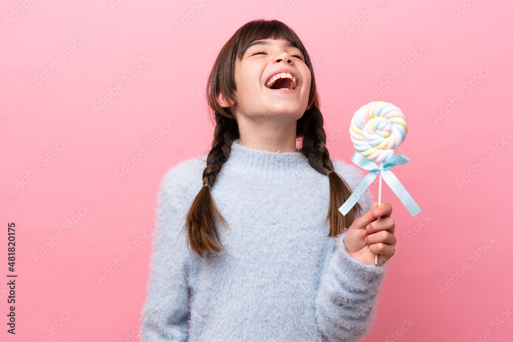 Little caucasian girl holding a lollipop laughing Little caucasian girl holding a lollipop laughing