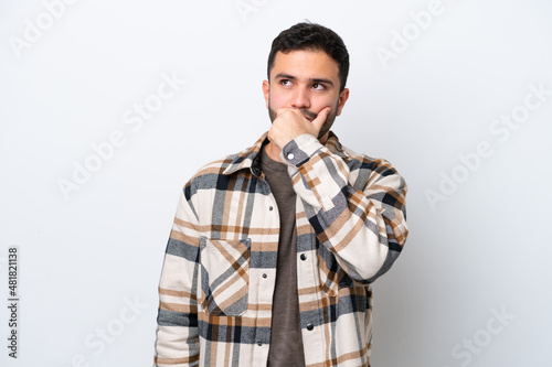 Young Brazilian man isolated on white background having doubts and with confuse face expression