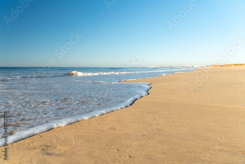 soft wave on the long sandy beach of Vilamoura in the Algarve in Portugal. photo