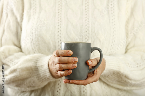 Hot tea in mug and woman hands 