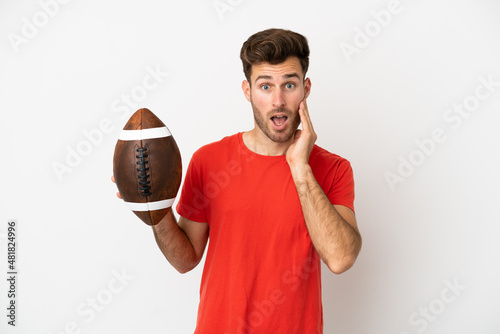 Young caucasian man playing rugby isolated on white background with surprise and shocked facial expression photo