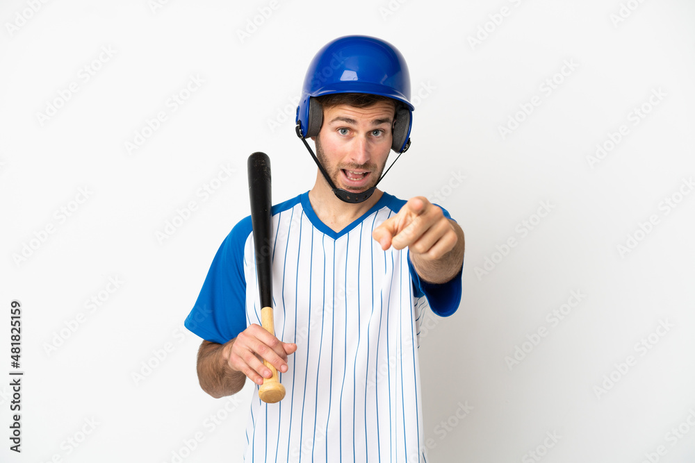 Young caucasian man playing baseball isolated on white background surprised and pointing front Young caucasian man playing baseball isolated on white background surprised and pointing front