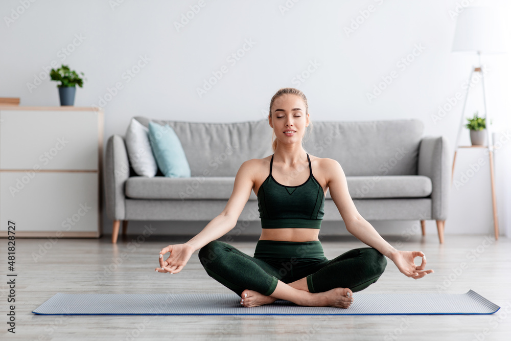 Calm caucasian pretty young blonde lady with closed eyes practicing yoga, breath, exercising at home Calm caucasian pretty young blonde lady with closed eyes practicing yoga, breath, exercising at home