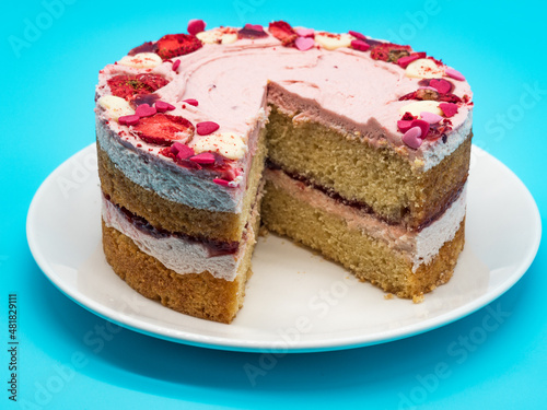 Valentine's day cake with sliced strawberry, blue background