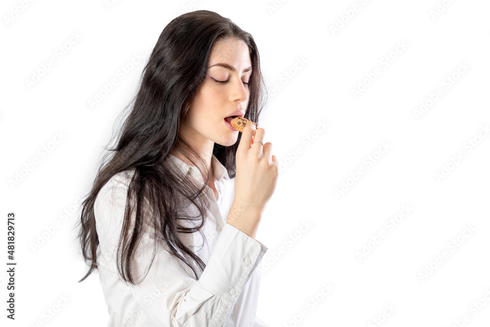 Woman eating a cookie. Isolated on white background. 20-22 years old. White european woman. Woman eating a cookie. Isolated on white background. 20-22 years old. White european woman.