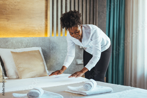 Canvas Print African maid making bed in hotel room