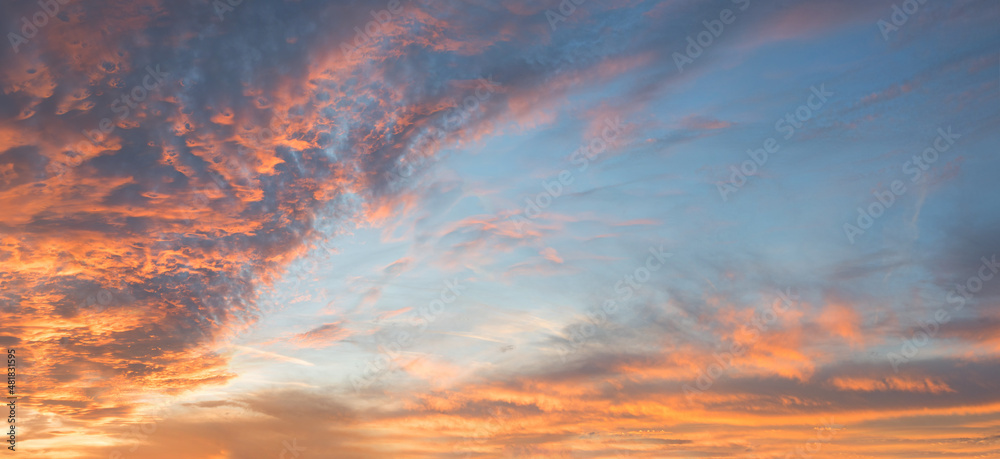 dreamy sunset scenery with pink and orange lighted clouds, blue sky