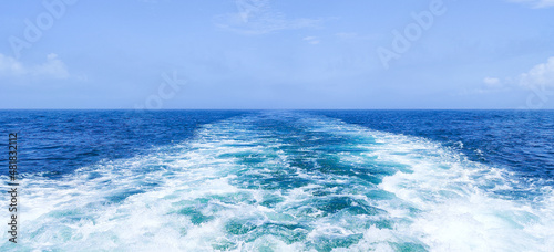 Trail on water surface behind of fast moving or sailing ship or boat © James Jiao