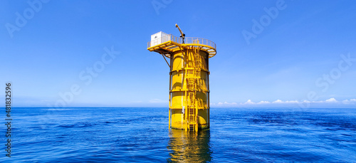 offshore construction of foundation for wind turbine to convert the wind's kinetic energy into electricity in Pearl River Estuary, China, with clouds and blue sky