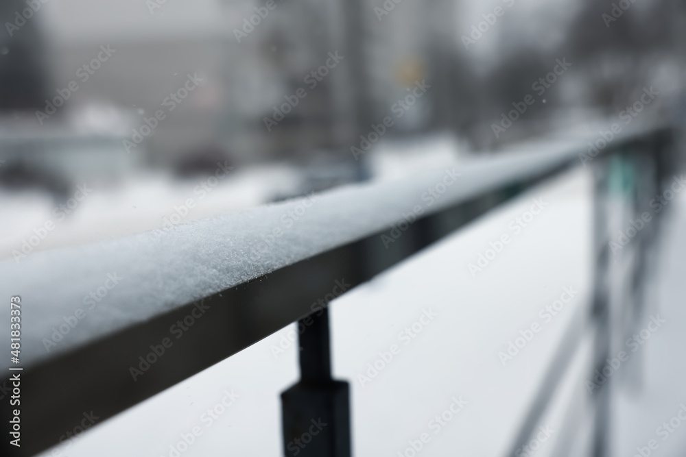 Handrail covered with snow outdoors, closeup view