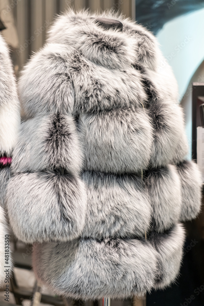 Fur coats in a row on a hanger in the store. Female fashion, natural mink fur clothes of different colors Fur coats in a row on a hanger in the store. Female fashion, natural mink fur clothes of different colors