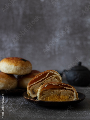 Tau Sar Piah (Savory Mung Bean Paste Biscuit) on rustic background with Chinese Tea Set with copy space. photo