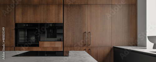 Modern minimalistic kitchen with black and wooden surfaces, marble kitchen island top and household appliances. Modern Concept For Interior Design And Architecture.