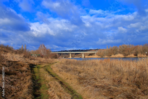 Autumn landscape of the river bank near the bridge.