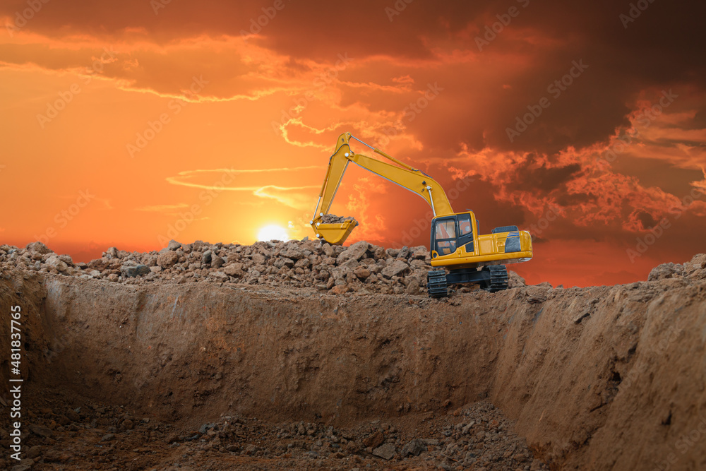 Crawler Excavators are digging the soil in the construction site on sunset background Crawler Excavators are digging the soil in the construction site on sunset background