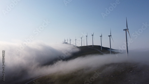 eolic generators spining over the mist in the mountains photo
