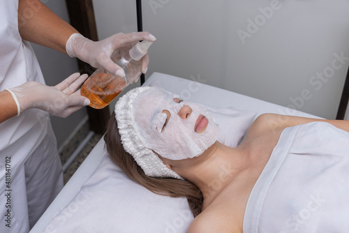 young woman in beauty center performing radio frequency therapy of facial complexion for skin beauty, applied by a beautician photo