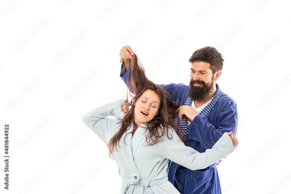 Happy family of man having fun with hair of woman sleeping and yawning in robes, sleepiness Happy family of man having fun with hair of woman sleeping and yawning in robes, sleepiness