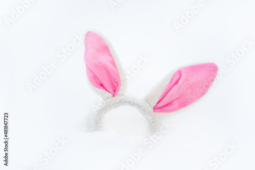 A headband in the form of rabbit ears in the snow in winter. Cute New Year concept