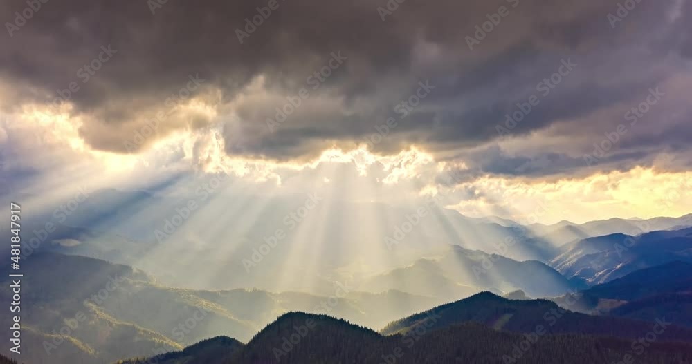 video of accelerated shooting from drone copter from a bird's eye view, time laps, clouds and rays of sunset quickly fly over the mountain peaks and valleys. Carpathians, Ukraine.