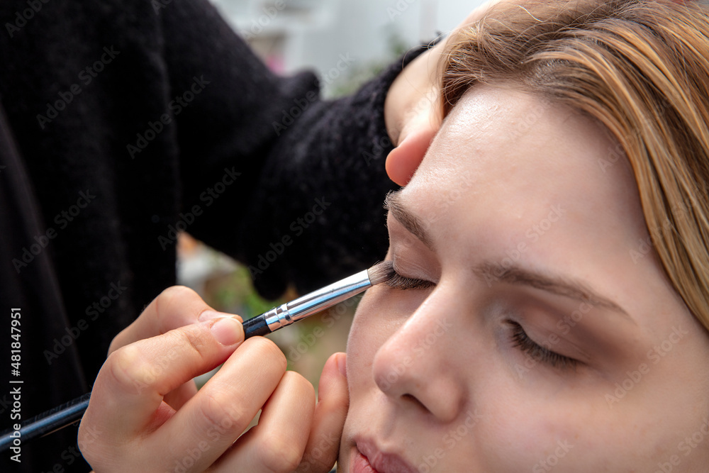 Eye makeup woman applying eyeshadow powder. Woman Make-up Applying closeup. Cosmetic Eyeshadows. Eyeline brush for Make up. Beauty Girl with Perfect Skin.
