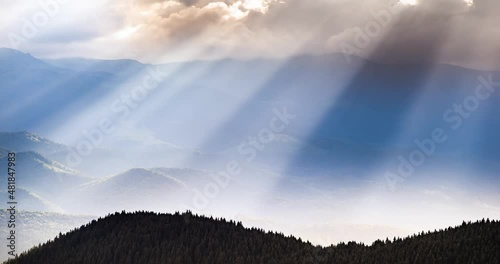 video of accelerated shooting from drone copter from a bird's eye view, time laps, clouds and rays of sunset quickly fly over the mountain peaks and valleys. Carpathians, Ukraine.