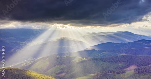 video of accelerated shooting from drone copter from a bird's eye view, time laps, clouds and rays of sunset quickly fly over the mountain peaks and valleys. Carpathians, Ukraine.