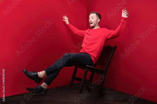 misadventure shows fall from chair with hands wide open looks like he is flying while his face shows surprised expression photo