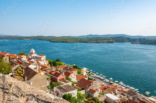 Coastal view of Sibenik old city, Croatia. Cathedral of St James, adriatic sea with island in background. Summer weather, aerial view of city roofs. UNESCO heritage.