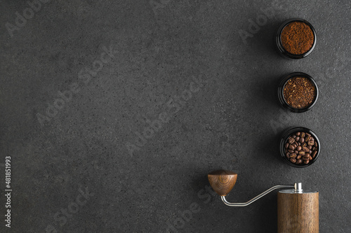 Slika na platnu Manual Coffee grinder and jars of fresh ground coffee from roasted beans on wooden rustic table