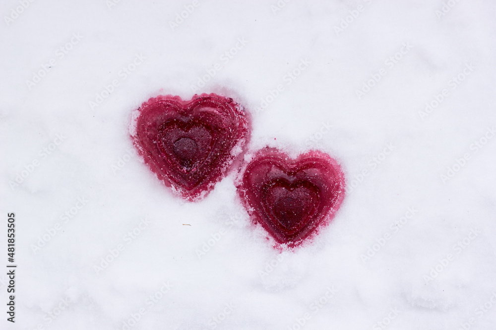 Two red ice hearts in the snow. The concept of love, relationships, Valentine's day