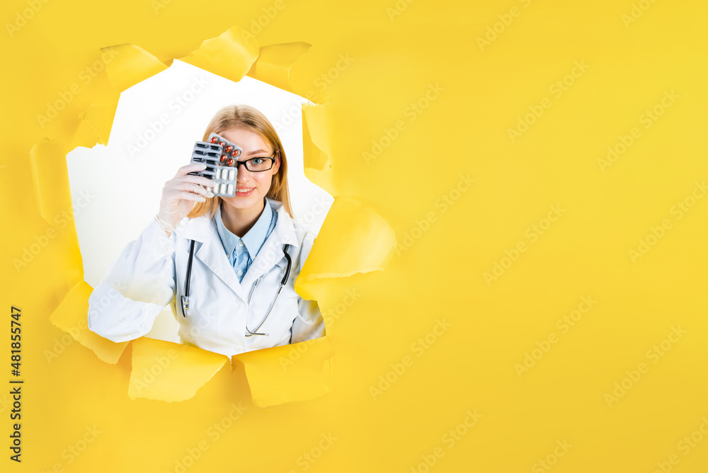 Young blond woman in white uniform in torn hole of yellow background. Female doctor is ready to patient visit. Professional therapist at work. Medicine, health care concept. Insurance card template.