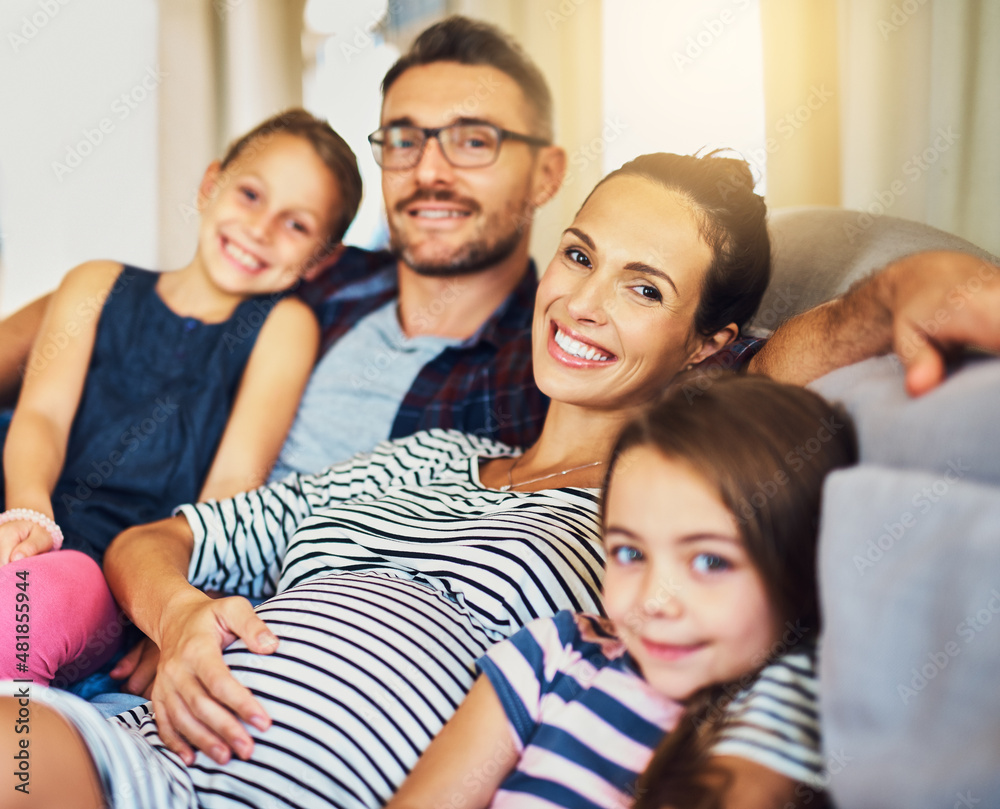 Happiness is time with the family. Cropped portrait of a happy young family of four relaxing on the sofa in their home.