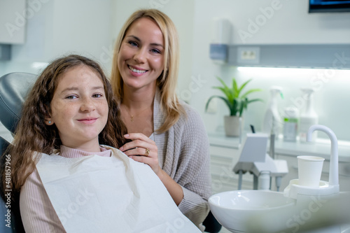 Foto Smiling mother and her cheerful daughter having dentist appointment