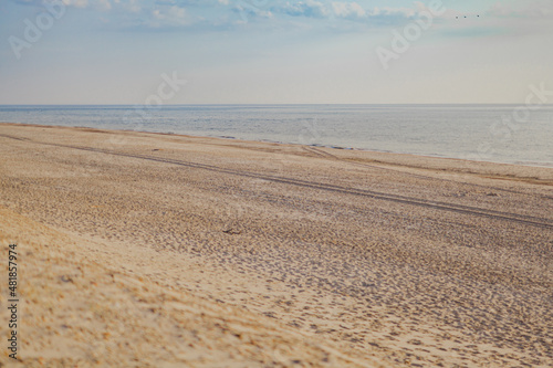 empty wide beach against blue ocean