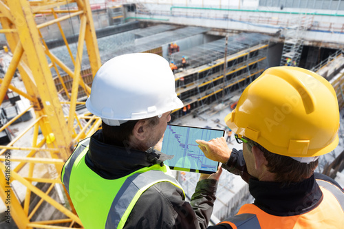 Obraz na plátně teamwork workers engineer architect with hard hat checking together construction