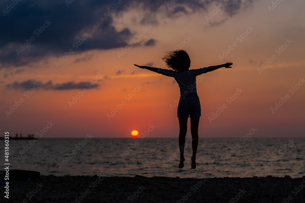 Happy young woman having fun with open hands at the sunset on sea. Happy young woman having fun with open hands at the sunset on sea.