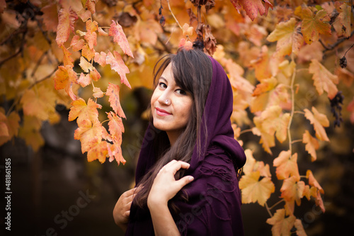 Outdoor portrait of beautiful young woman and colorful autumn leaf