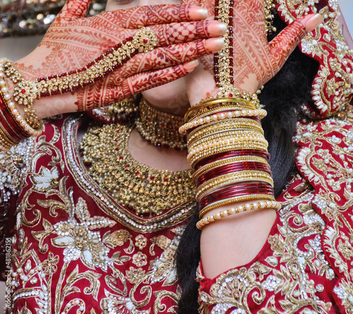 Beautiful Indian bride hands henna design hand jewelry kalira and red nail paint. photo