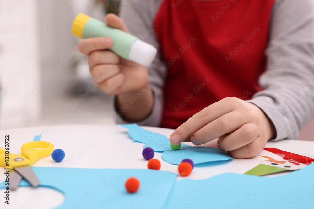 Little child making Christmas craft at white table, closeup Little child making Christmas craft at white table, closeup
